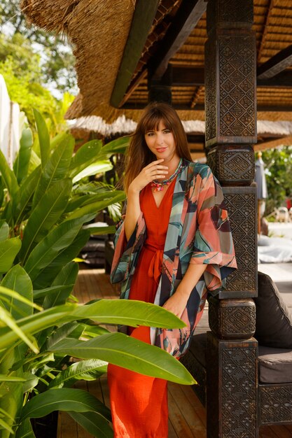 Остров моды. Соблазнительная стильная женщина в богемной летней одежде позирует в тропическом роскошном курорте. Концепция отпуска.