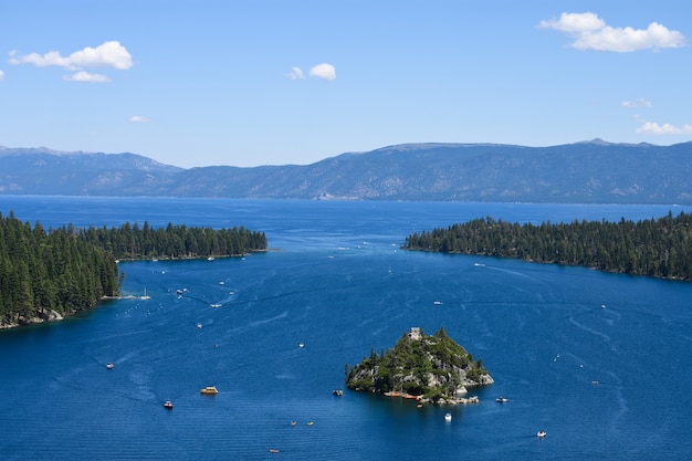 An isle isolated in the ocean surrounded by fir tree islands and high rocky mountains