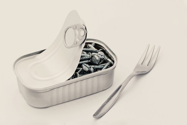 Isolated of a fork and a can filled with screws on white background