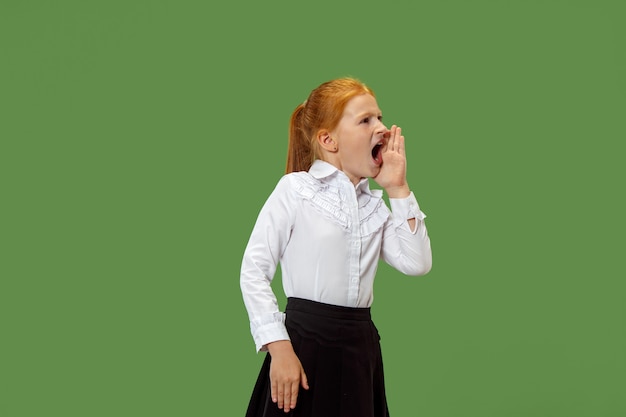 Isolated on green young casual teen girl shouting