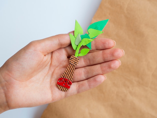 Isolated homemade paper plant held in hand