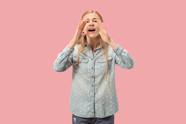 Isolated on pink young casual woman shouting at studio