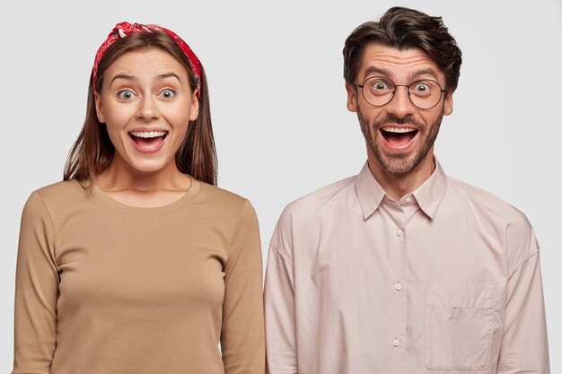 Isolated shot of of cheerful best friends posing against the white wall