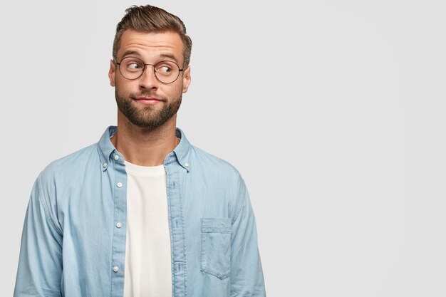 Isolated shot of funny bearded guy posing against the white wall