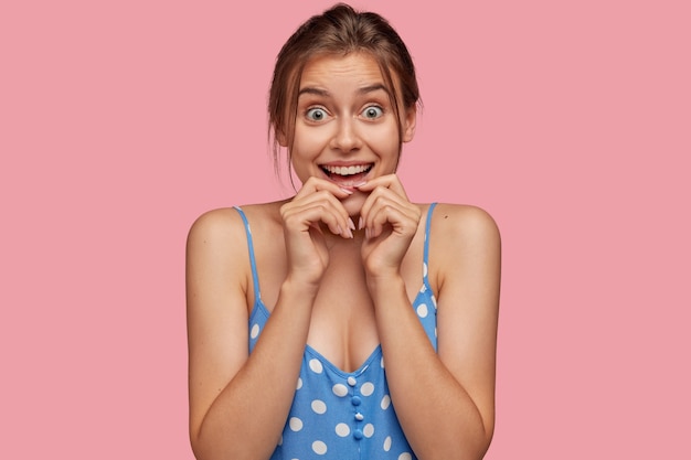 Isolated shot of glad Caucasian woman looks with eyes full of happiness