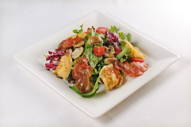 Free photo isolated shot of a plate with salad with chicken and bacon - perfect for a food blog or menu usage