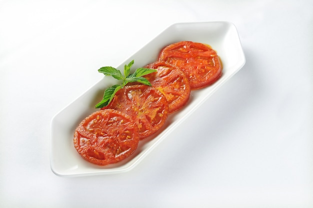 Isolated shot of a plate with slices of grilled tomatoes - perfect for a food blog or menu usage