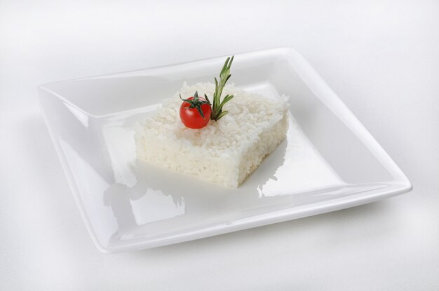 하얀 접시에 사각형 모양의 쌀의 고립 된 총