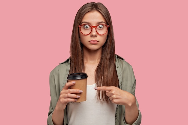 Free photo isolated shot of stunned student posing against the pink wall