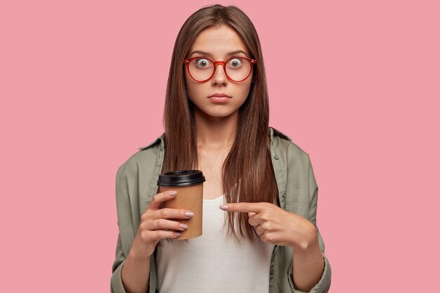 Isolated shot of stunned student posing against the pink wall