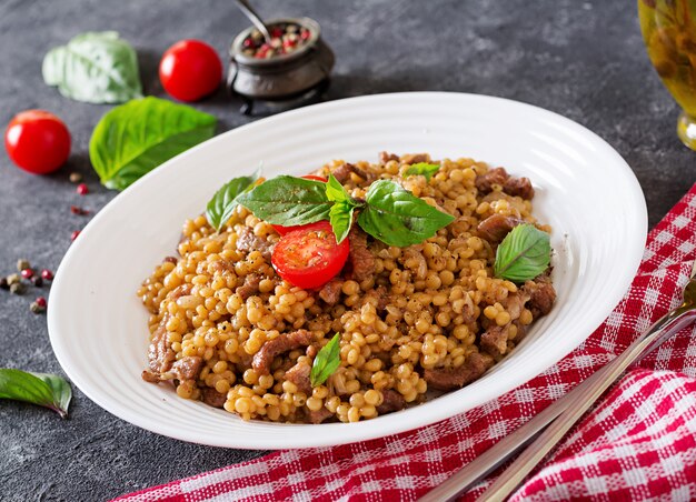 Israeli couscous with beef. Tasty food. Asian meal.