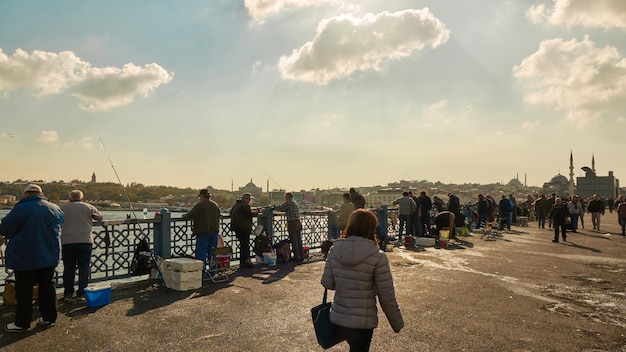無料写真 イスタンブールトルコ2017年11月25日晴れた日にガラタ橋で釣りをする人々
