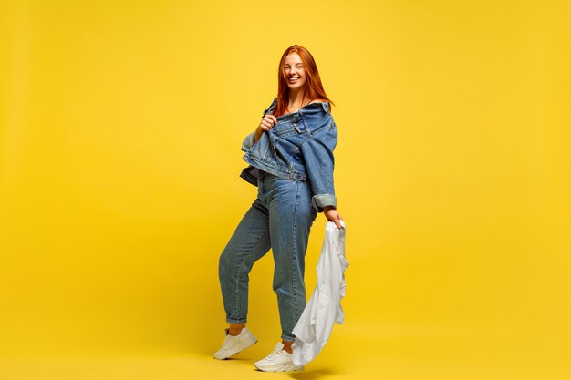 It's easier to be follower. Laundry faster, if it's only one shirt. Caucasian woman's portrait on yellow background. Beautiful red hair model. Concept of human emotions, facial expression, sales, ad.