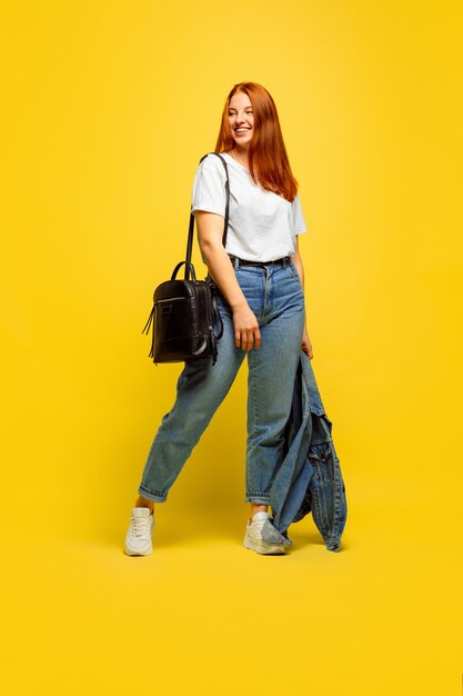 It's easier to be follower. Need minimum clothes to go. Caucasian woman's portrait on yellow background. Beautiful female red hair model. Concept of human emotions, facial expression, sales, ad.