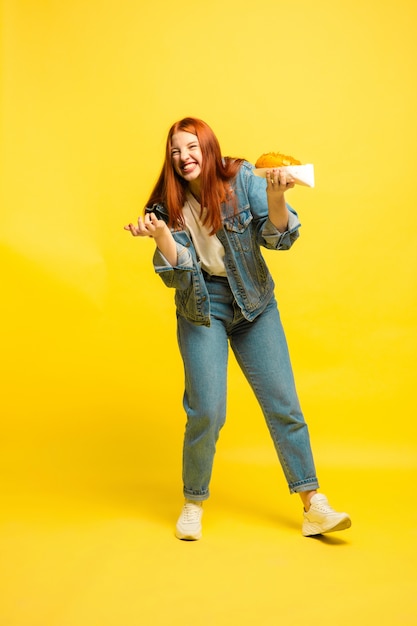 It's easier to be follower. don't need to take photo with food. caucasian woman's on yellow background. beautiful female red hair model. concept of human emotions, facial expression, sales, ad.