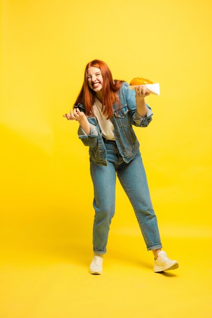 It's easier to be follower. Don't need to take photo with food. Caucasian woman's on yellow background. Beautiful female red hair model. Concept of human emotions, facial expression, sales, ad.