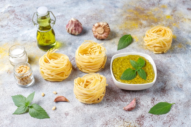 Italian basil pesto sauce with culinary ingredients for cooking.