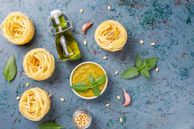 Italian basil pesto sauce with culinary ingredients for cooking.