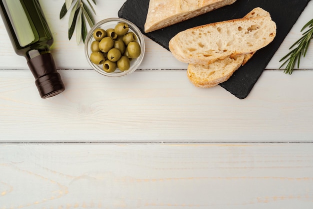 木製の背景にオリーブオイルとイタリアンチャバタパン