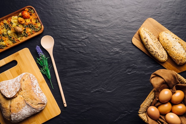 Foto gratuita composizione di cibo italiano con pane, uova e spazio in mezzo