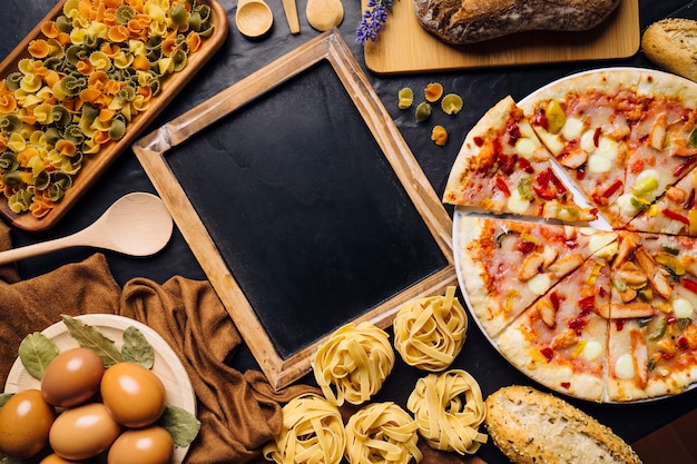 Italian food composition with slate and pizza