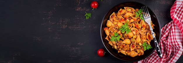 Italian pasta shells with mushrooms, zucchini and tomato sauce