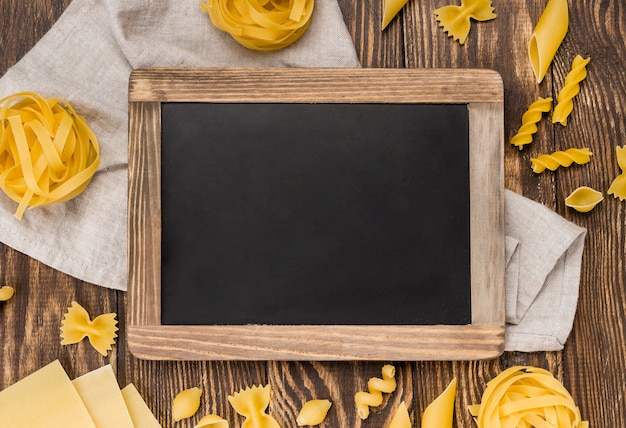 Italian pasta in spoons beside chalkboard