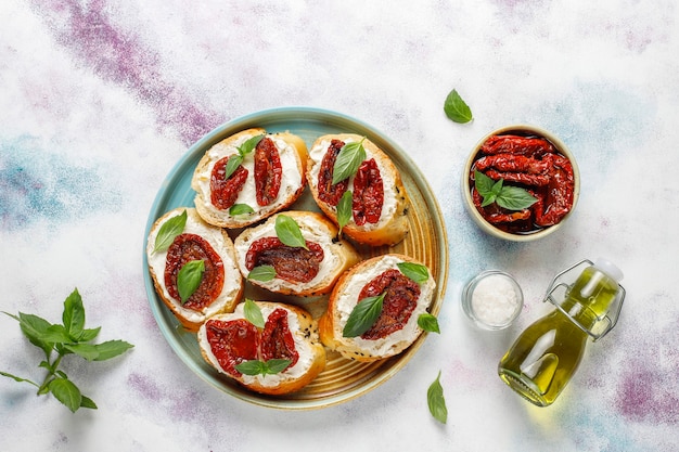 Foto gratuita panini italiani - bruschette con formaggio, pomodori secchi e basilico.