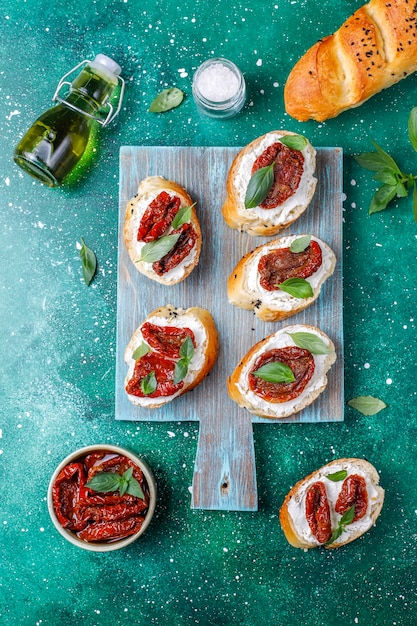 Italian sandwiches - bruschetta with cheese, dry tomatoes and basil.