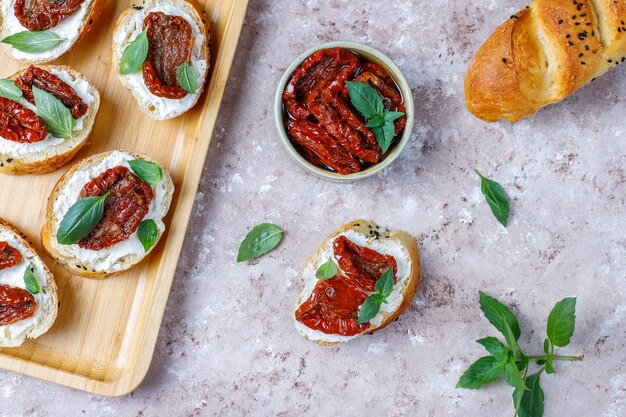 Italian sandwiches - bruschetta with cheese, dry tomatoes and basil