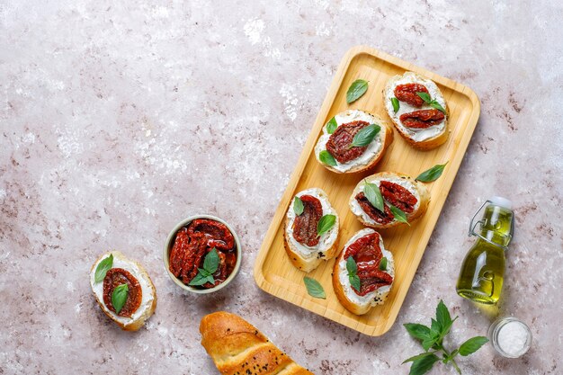 Italian sandwiches - bruschetta with cheese, dry tomatoes and basil.