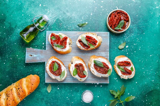 Italian sandwiches - bruschetta with cheese, dry tomatoes and basil.