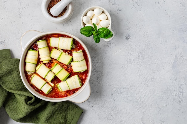 Итальянские булочки из zucchini с начинкой из сливочного сыра, выпеченные в томатном соусе на белом фоне