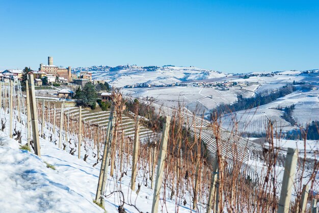 イタリアピエモント​：​ワイン​ヤード​の​列​、​雪​の​ある​冬​の​ユニークな​風景​、​丘​の​上に​ある​田舎​の​村​、​イタリア​の​歴史的​遺産​ネッビオーロブドウ​農業​の​パノラマビュー