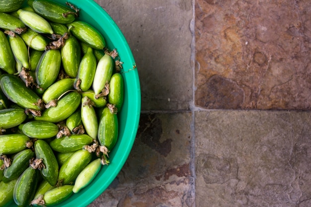 Ivy gourd soaking in water on vintage tiles