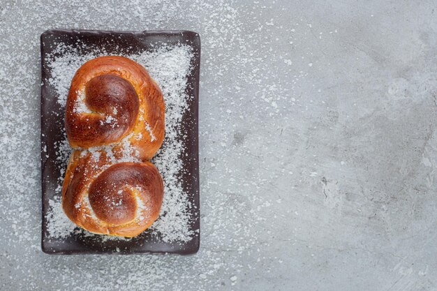 Jam filled sweet bun on a platter on marble table.