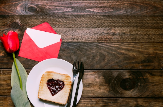 Foto gratuita marmellata a forma di cuore su pane tostato con tulipano