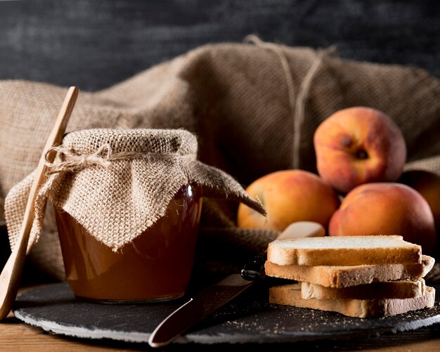 Jam jar with peaches and bread