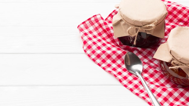 Jam jars on white wooden background