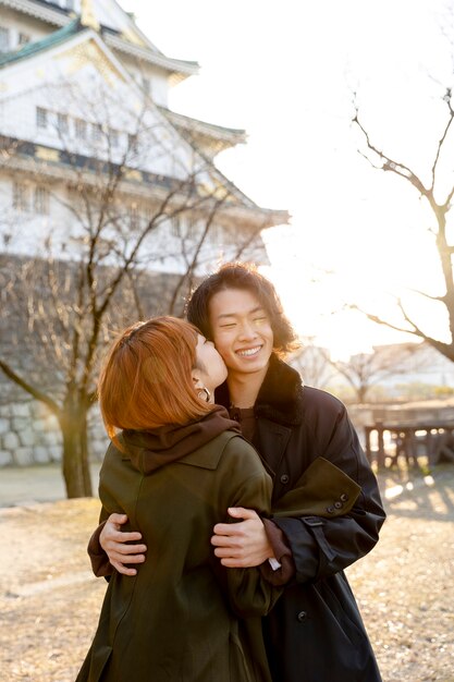白い日に屋外で抱き締める日本人カップル