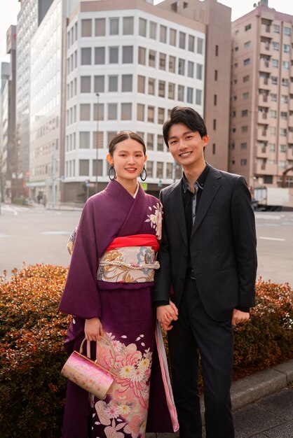 屋外でポーズをとり、成人の日を祝う日本人カップル