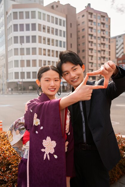 屋外でポーズをとり、成人の日を祝う日本人カップル
