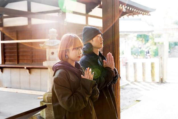Бесплатное фото Японская пара молится в храме во время свидания