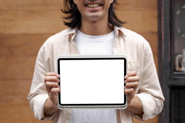 Japanese designer showing a digital tablet screen outside his sh