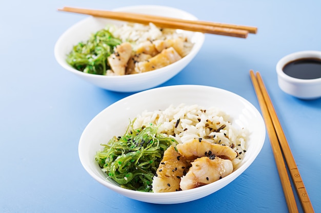 일본 음식. 밥 그릇, 삶은 흰살 생선, 와카 메 추카 또는 해초 샐러드.