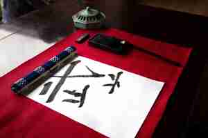 Бесплатное фото Японский почерк на бумаге и расположение инструментов