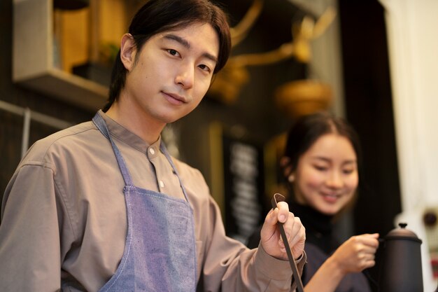 일본 여자가 레스토랑에서 요리하는 동안 포즈를 취하는 일본 남자
