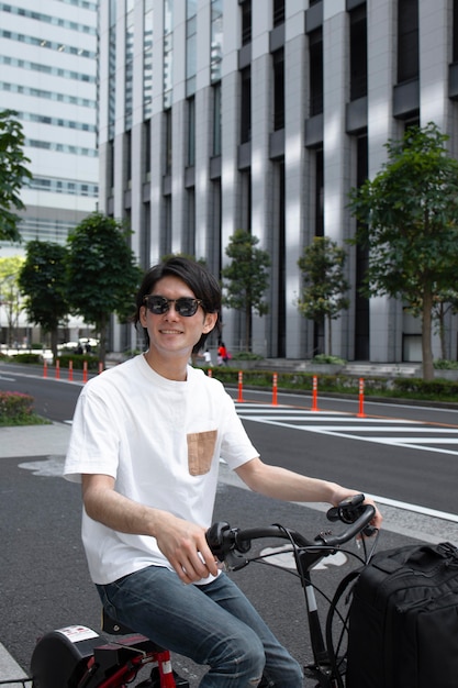 Uomo giapponese con la sua bici all'aperto