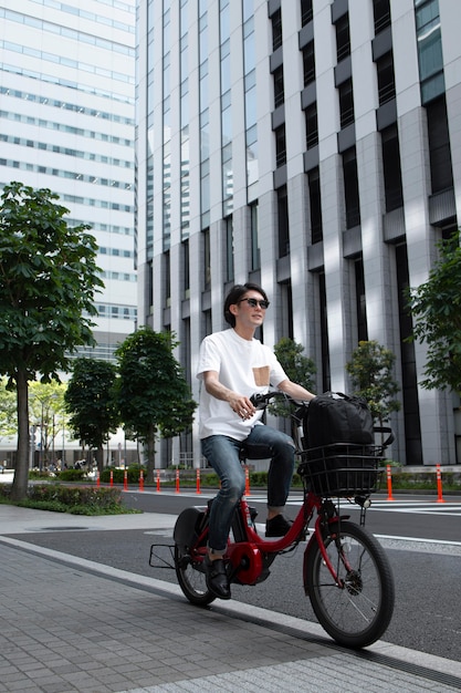 屋外で自転車を持っている日本人男性