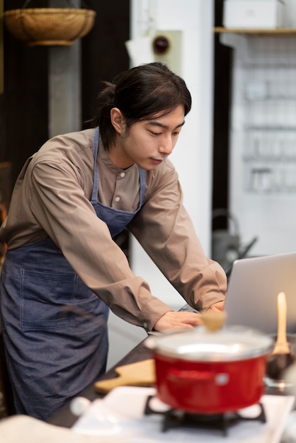 Foto gratuita uomo giapponese che lavora al suo computer portatile in un ristorante